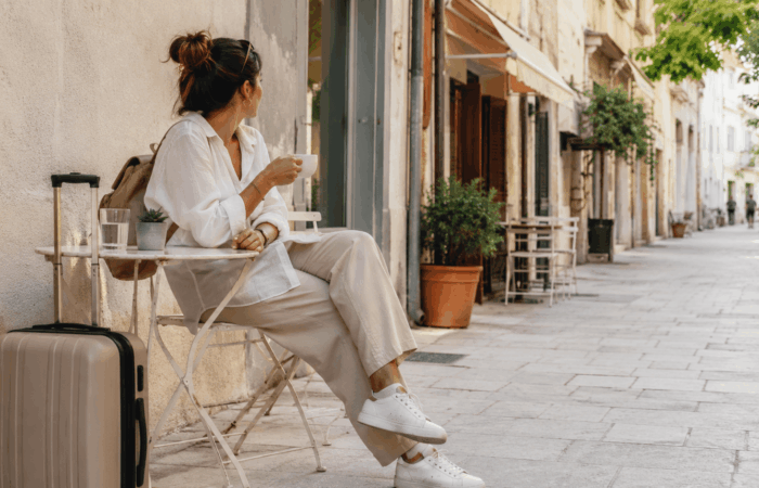 Traveler with suitcase at a café in Athens after hotel check-out